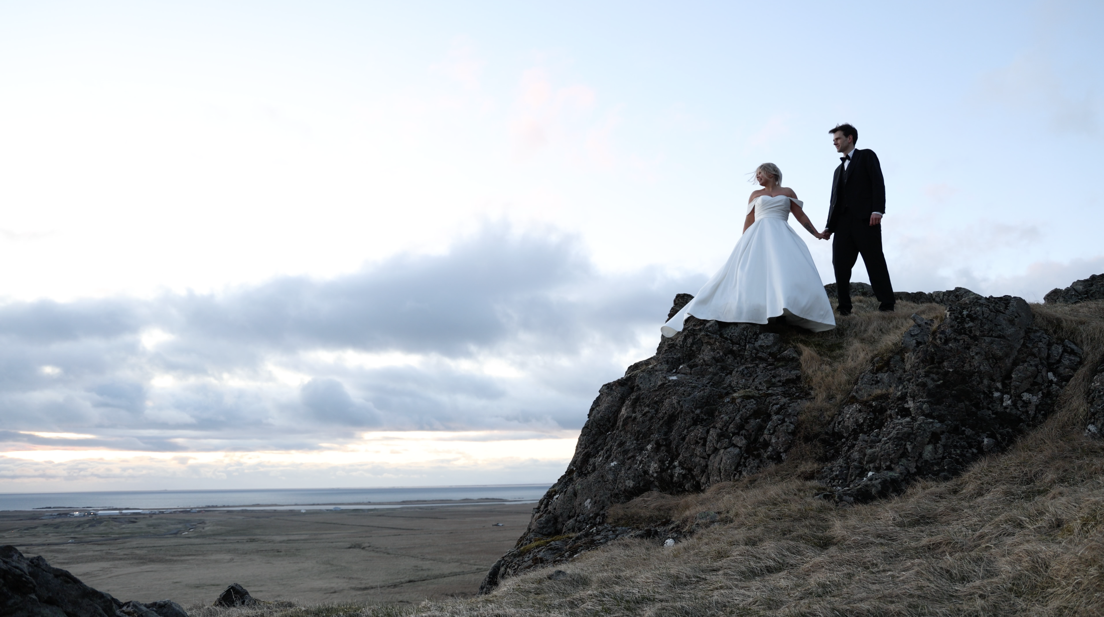 Iceland elopement couple stand on ledge with open views