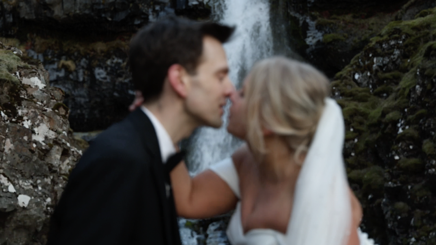Iceland elopement couple kiss at waterfall
