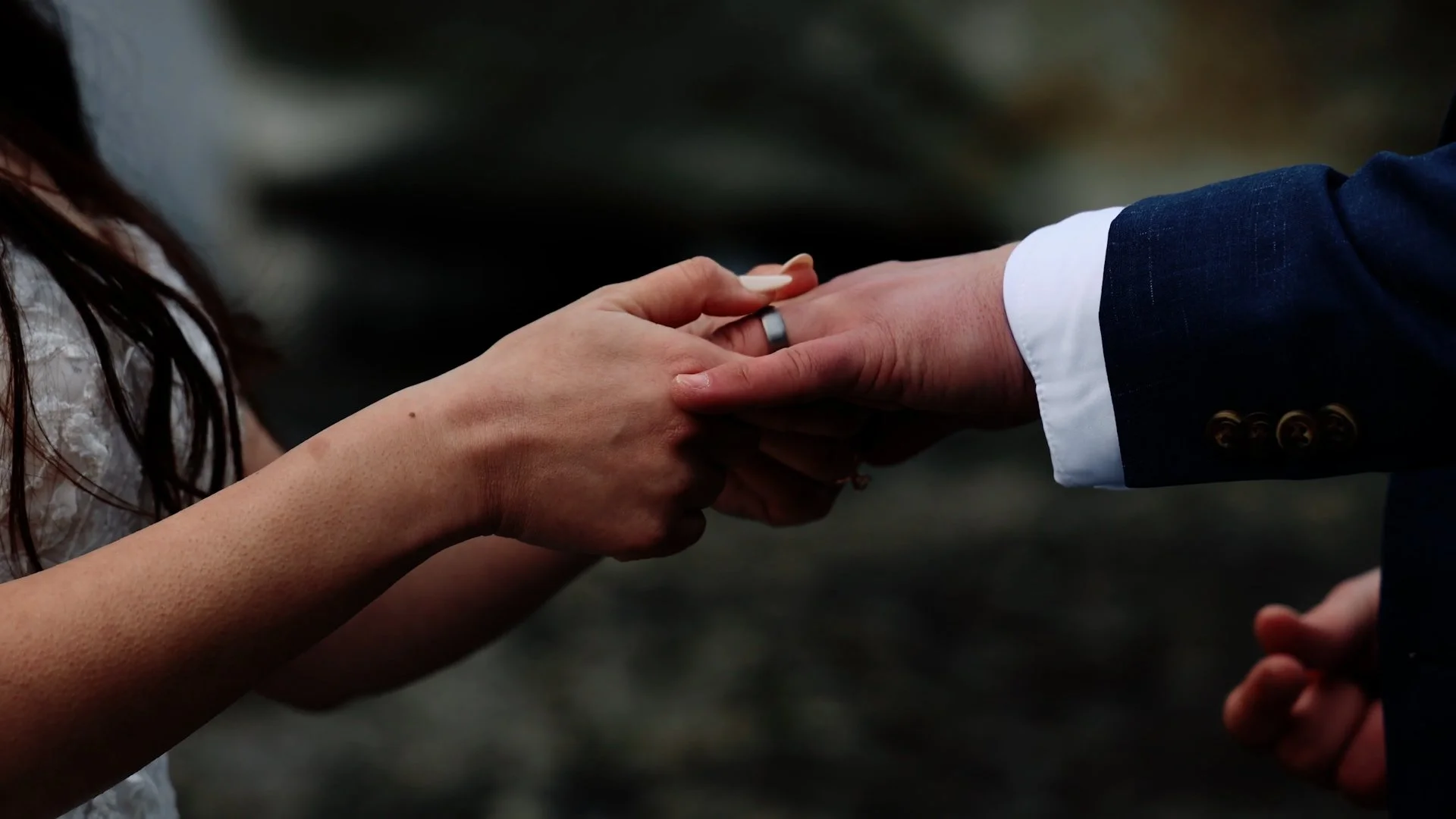 Bride puts ring on groom finger exchanging rings during an Iceland elopement ceremony
