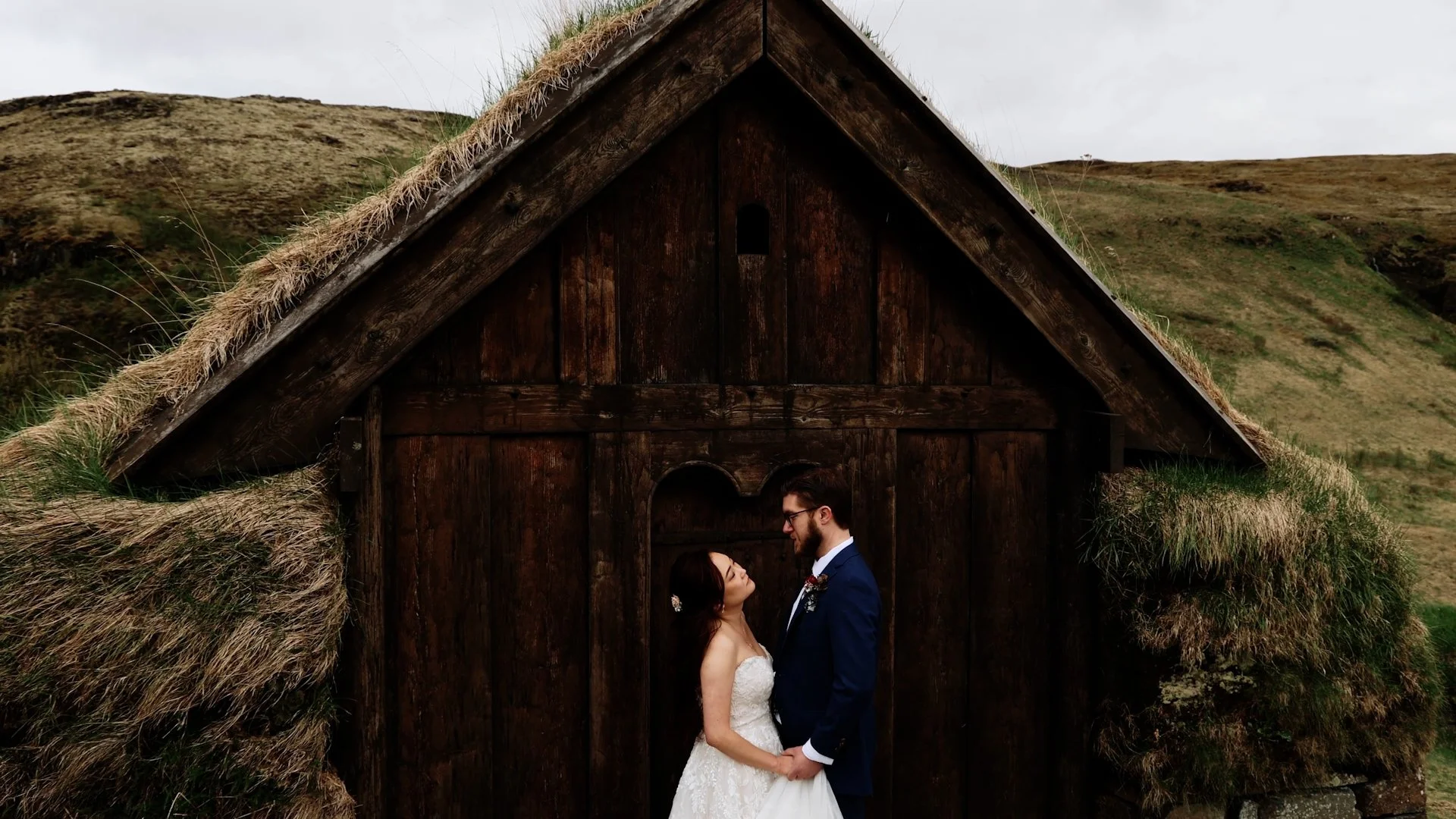 Couple by a Viking house wooden door a quiet moment between locations during an Iceland elopement day
