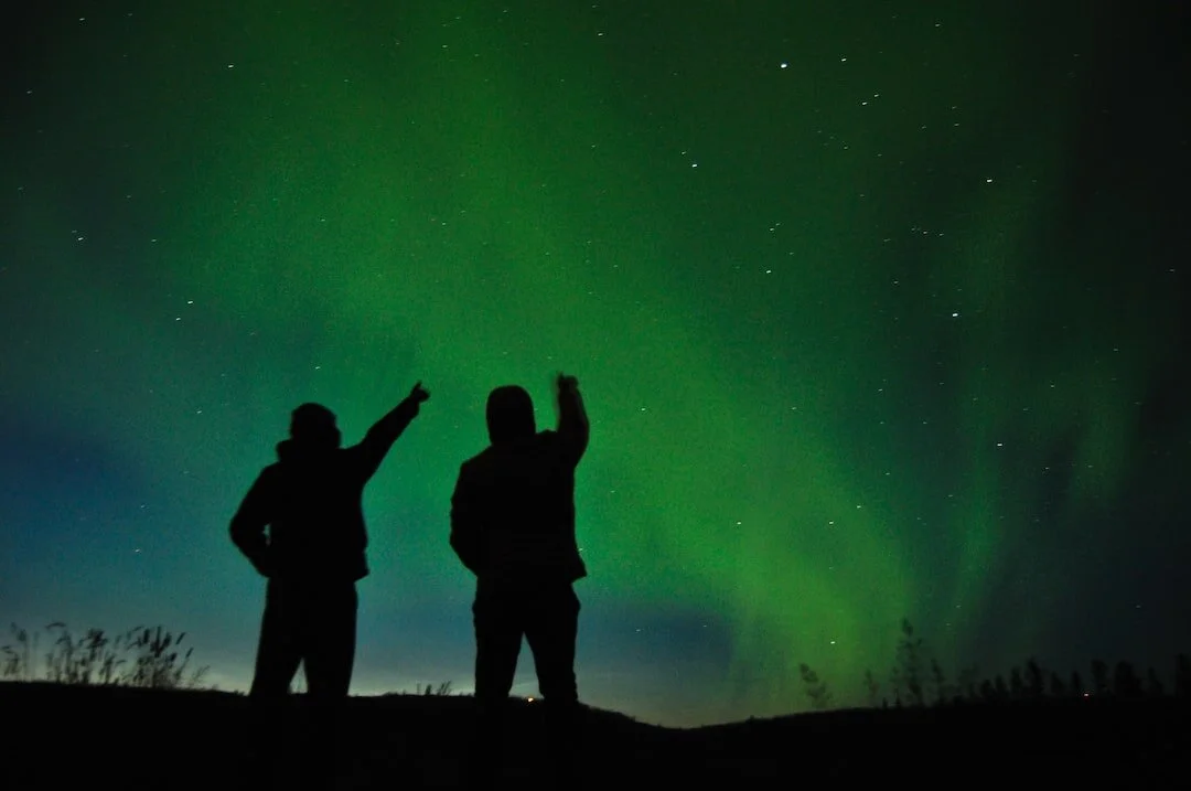 Couple point at northern lights in Iceland