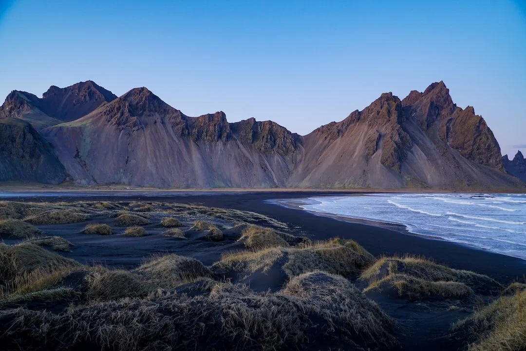 Jagged mountains by black sand beach in Iceland
