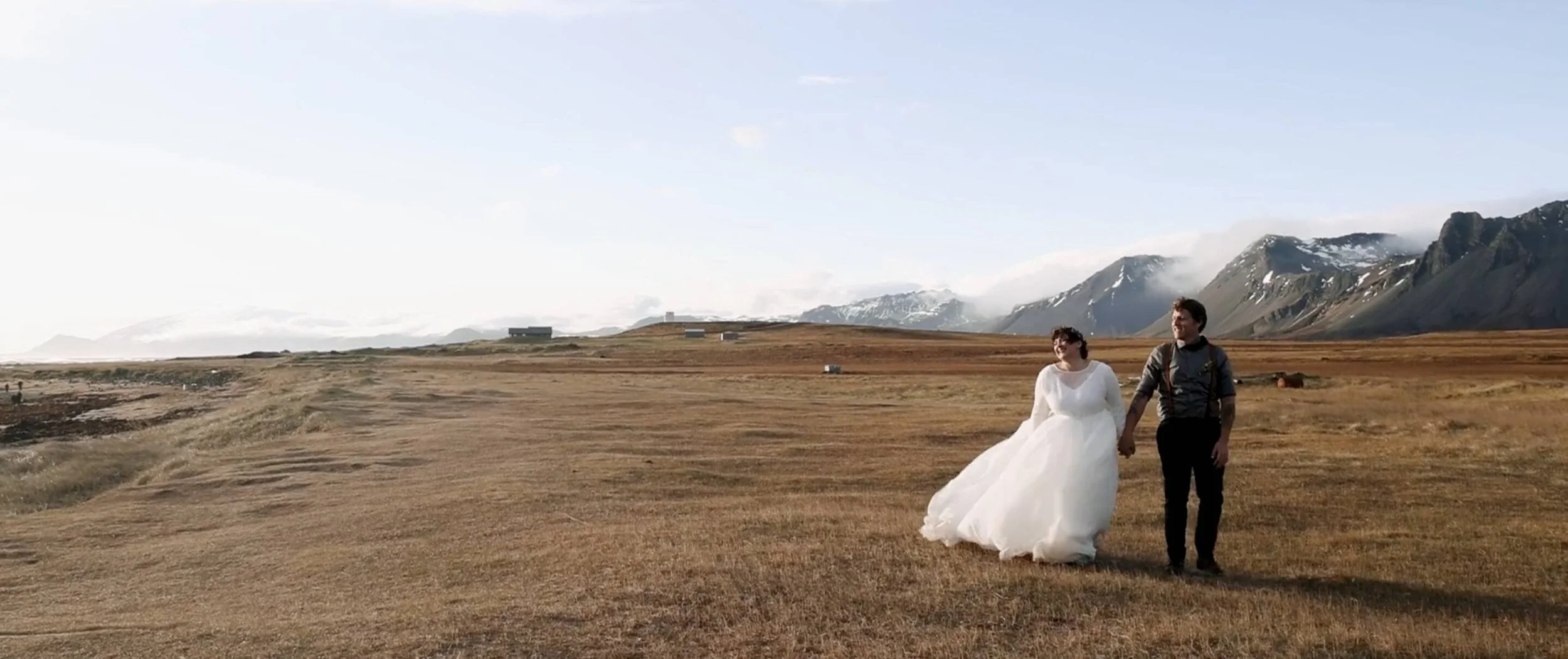 iceland elopement couple walking in front of mountain backdrop